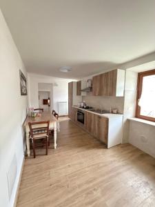 a kitchen with a wooden table and a dining room at Casa Saotta in Collimento +3 photos