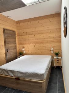 a bedroom with a bed in a wooden wall at Appartement à La Bresse - cadre naturel et calme in La Bresse