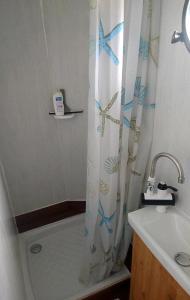 ein Badezimmer mit einem Duschvorhang neben einem Waschbecken in der Unterkunft La Salicorne hébergement insolite in Saint-Germain-sur-Ay + 19 Fotos