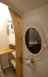 ein Bad mit einem runden Spiegel an der Wand in der Unterkunft La Salicorne hébergement insolite in Saint-Germain-sur-Ay