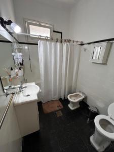 a bathroom with a white shower curtain and a toilet at La Casita de Salta 421 in Concordia +5 photos