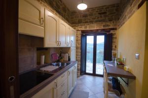 a kitchen with a sink and a counter with a window at Dimore dell'Olmo - Ospitalità Diffusa in Castelmezzano