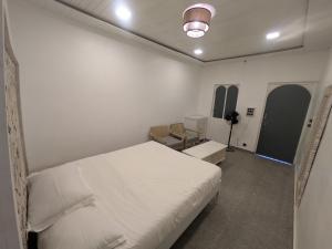 a white room with a bed and a desk at Nomada in Mount Ābu
