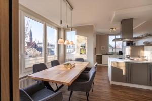 a kitchen and dining room with a wooden table and chairs at Rodehuus Wohnung 8 in Borkum