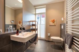 a bathroom with a sink and a toilet at Rodehuus Wohnung 8 in Borkum +6 photos