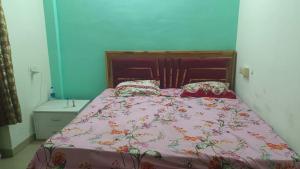 a bedroom with a bed with a pink comforter and pillows at Raj Guest House in Dombivli