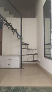 a room with stairs and a dresser and a mirror at Raj Guest House in Dombivli