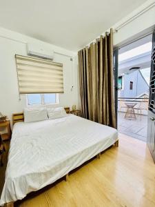 Cồn Giả ViênにあるThảnh Thơi HomeStay & Yogaのベッドと大きな窓のある寝室 +5枚の写真