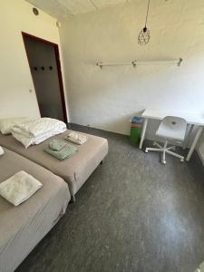 a room with two beds and a desk and a computer at Campus Djursland in Grenå