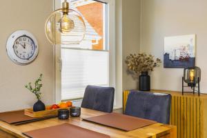 a dining room with a table and a clock on the wall at Pier17 Appartement 5 in Borkum