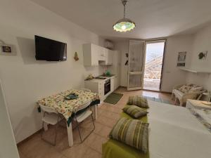 a living room with a table and a kitchen at Monolocale Santa Caterina in Santa Caterina di Nardò