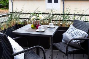 a table with two chairs and cups on a patio at Pier17 Appartement 5 in Borkum