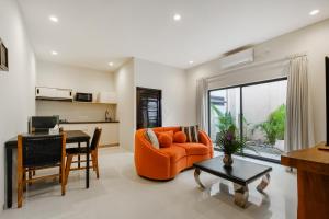 a living room with an orange couch and a table at Amelia D Art Deco Suites in Seminyak