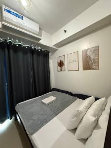 a bedroom with a large bed with black curtains at Sea Residences MOA Pasay City - Rose Staycation in Manila