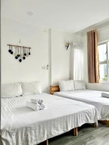 Cồn Giả ViênにあるThảnh Thơi HomeStay & Yogaの寝室に並んで置かれた2つのベッド