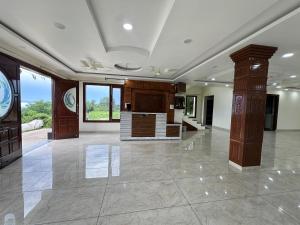 a large room with a lobby with wooden pillars at The Ananta Palampur in Pālampur
