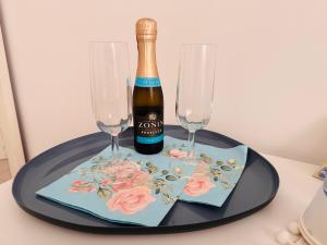 a bottle of champagne and two wine glasses on a table at Avia Room in Pachino
