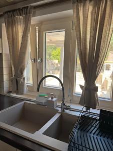 a kitchen with a sink and two windows at Geropalas Spacious Garden House in Vlachopoulátika +25 photos