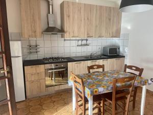 a kitchen with a table and a kitchen with a stove at Agriturismo Il Giglio di Sant' Antonio in Montemassi