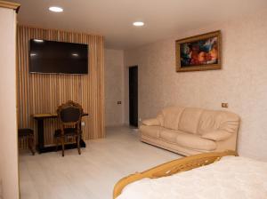 a living room with a couch and a flat screen tv at AMSTERDAM hotel&swimming pool in Suprunovka +25 photos
