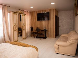 a bedroom with a bed and a couch and a table at AMSTERDAM hotel&swimming pool in Suprunovka