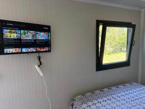 a room with a bed and a window and a wall at Mobilna kucica M in Donji Štoj