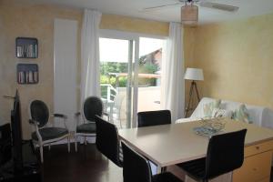 a living room with a dining room table and chairs at Au Cœur De La Riviera Des Alpes T2 in Brison-Saint-Innocent