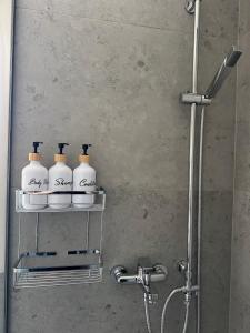 a bathroom with a shower with four soap bottles on a shelf at Geropalas Spacious Garden House in Vlachopoulátika
