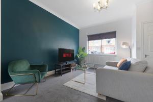 a living room with a couch and a tv at Your Home Away in Bishop Auckland