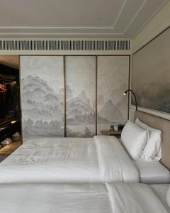 una camera da letto con un letto grande con un dipinto sul muro di Kashi residency palace a Varanasi