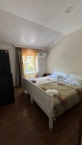 a bedroom with a large white bed and a window at Hotel Meidani in Borjomi