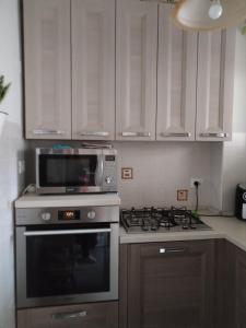 een keuken met een fornuis en een magnetron bij Casa Mari in Ancona