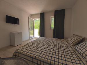 a bedroom with a bed and a tv and windows at The Brothers Villa in Ohrid