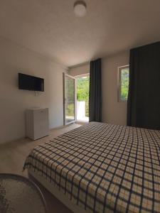 a bedroom with a bed with a checkered blanket and windows at The Brothers Villa in Ohrid