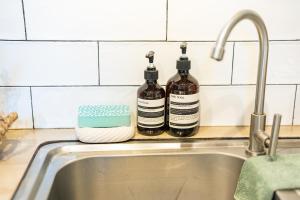 two bottles of alcohol sitting on a counter next to a sink at Casa Maria at Bigang Munti in San Juan