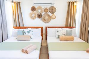 two beds in a room with hats on the wall at Casa Maria at Bigang Munti in San Juan