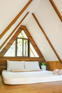 a bed in a loft with a window at Casa Maria at Bigang Munti in San Juan