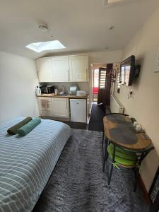 アトックシターにある16 BENTLEY ROAD - Uttoxeter, ENTIRE HOLIDAY HOME, COSY ACCOMMODATIONのベッド、テーブル、キッチンが備わる客室です。