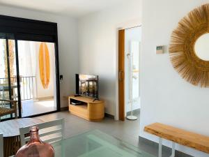 een woonkamer met een glazen tafel en een spiegel bij Flamingo Mojácar in Mojácar