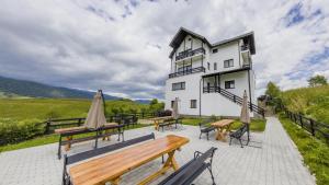 a building with benches and umbrellas in front of it at VILA LUCA-Hotel in Şirnea