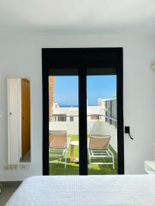 een slaapkamer met glazen schuifdeuren en uitzicht op de oceaan bij Flamingo Mojácar in Mojácar +59 foto's