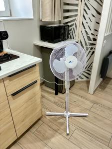 a white fan sitting in a kitchen next to a counter at Tiny room in Langres
