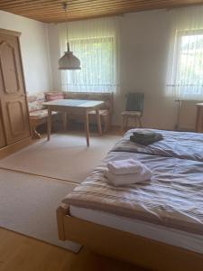 a bedroom with a bed and a table in it at Ferienwohnungen Gebhard in Scheidegg