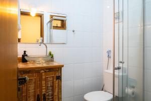 a bathroom with a sink and a toilet and a shower at Apartamento Le Quatre Avenida in Monte Verde