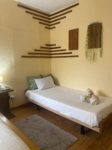 a bedroom with a white bed with a stuffed animal on it at Alojamento D Duarte in Gouveia
