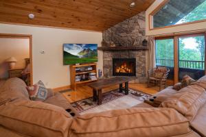 a living room with a couch and a fireplace at Get-away Cabin Hot Tub Sunsetmtn Views,asheville in Swiss