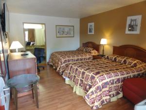 a hotel room with two beds and a table and a desk at Grand Rapids Inn in Grand Rapids