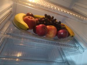 a plate of fruit in an open refrigerator at Haute qualité in Al Hoceïma