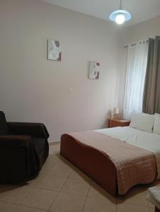 a bedroom with a bed and a chair in it at Gamila Sunrise in Konitsa