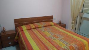 a bedroom with a bed with a colorful comforter at Casa Anna in Bosa